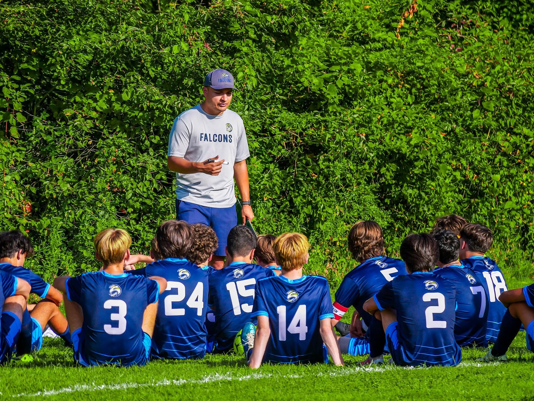 Coach Adrian Torres addressing the Falcons boys soccer team during a huddle